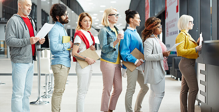 Menschen stehen in einer Schlange zur Registrierung